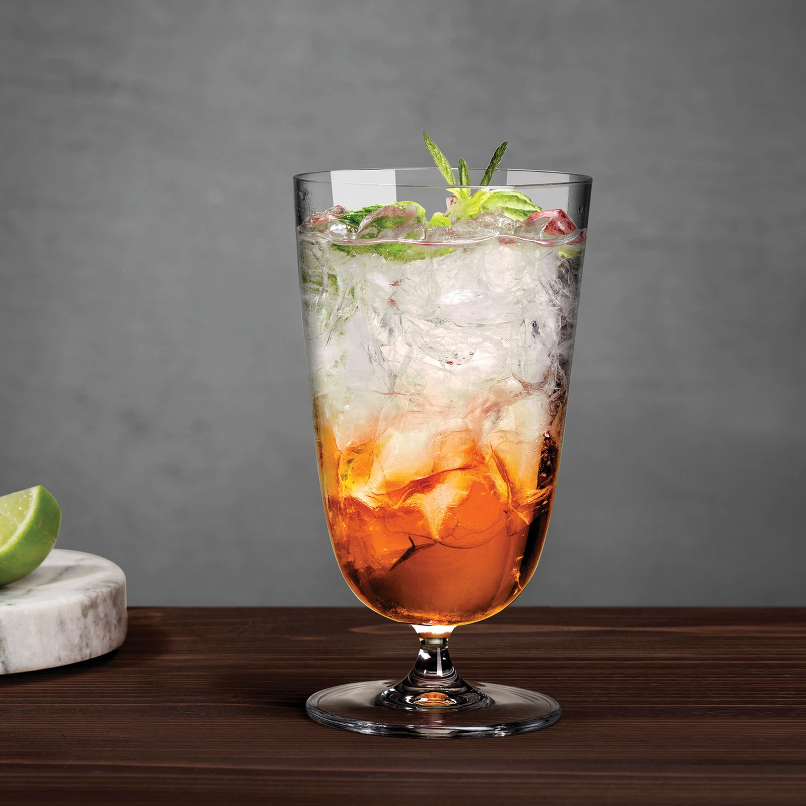 vaso highball Bargiani de NUDE de 37 cl sobre pie corto, servido con un combinado y hielo