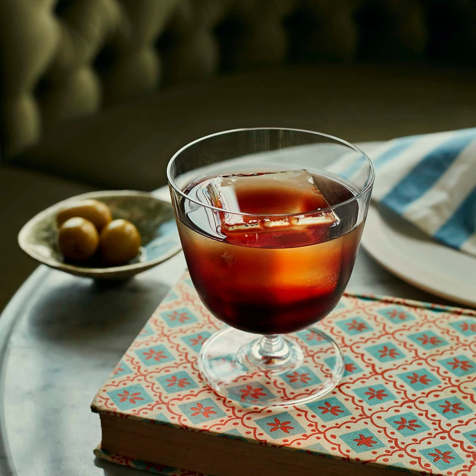 vaso old fashioned Bargiani de NUDE de 32 cl con un cóctel oscuro sobre la mesa