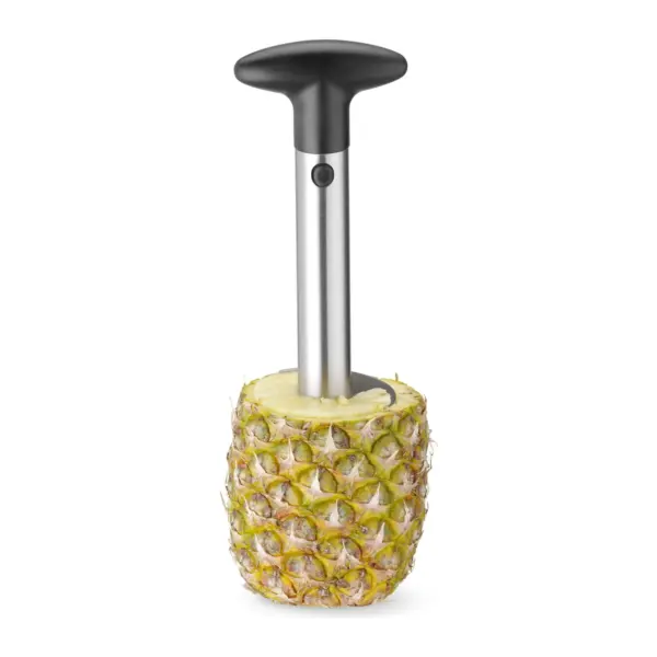 pelador de piña enroscado en la fruta, con la cáscara alrededor