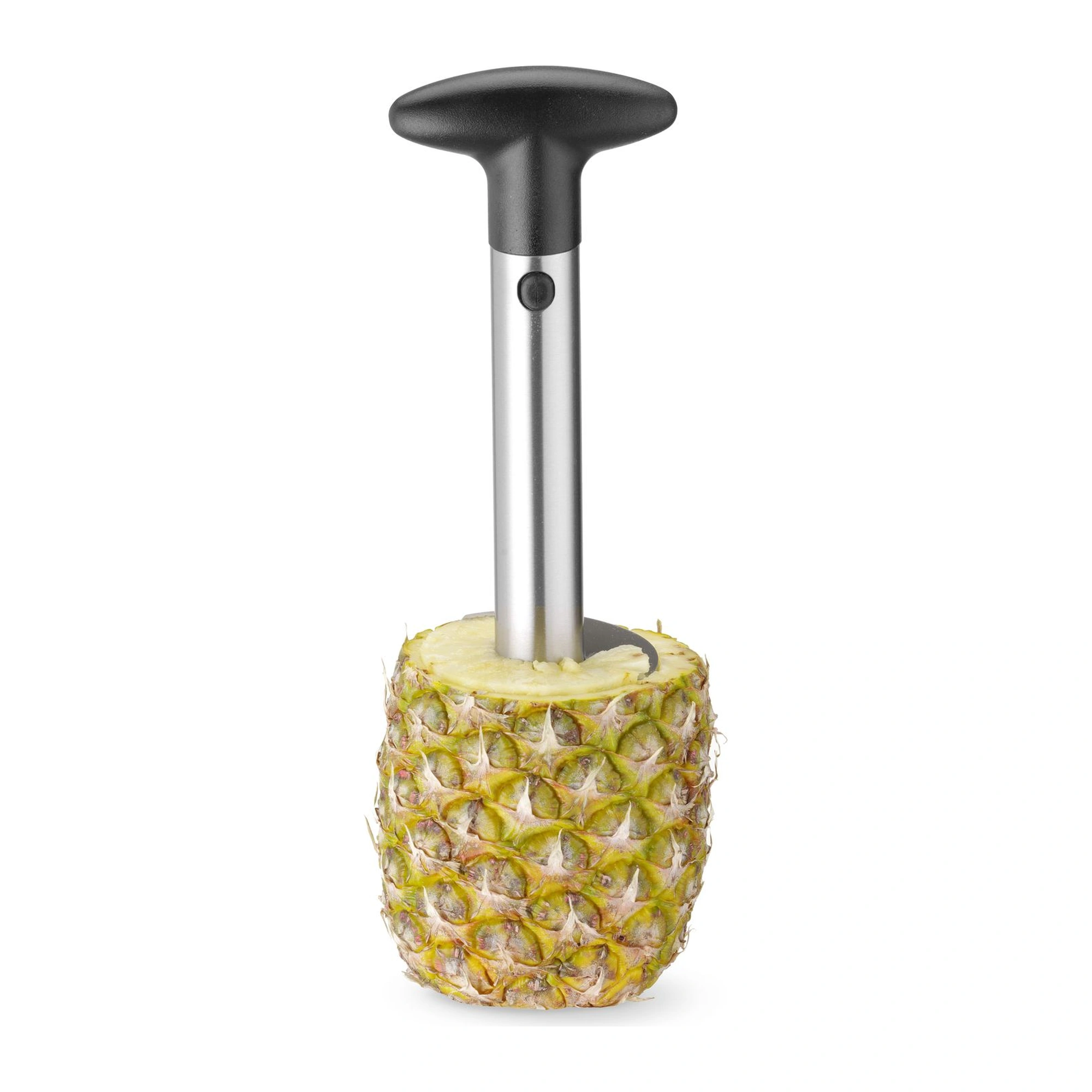 pelador de piña enroscado en la fruta, con la cáscara alrededor
